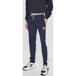 Hummel - Spodnie. Niebieskie spodnie sportowe męskie HUMMEL, z bawełny. W wyprzedaży za 139.90 zł.