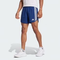 Szorty Own the Run 3-Stripes. Niebieskie szorty męskie Adidas, bez wzorów, z materiału, sportowe. Za 229.00 zł.
