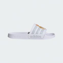 Klapki Adidas Adilette Real Madrid JS4863 - białe, unisex. Białe klapki damskie Adidas, bez wzorów, z materiału, bez obcasa. Za 107.99 zł.