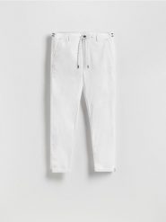 Bawełniane spodnie chino slim - biały. Białe spodnie materiałowe męskie Reserved, bez wzorów, z bawełny. Za 139.99 zł.