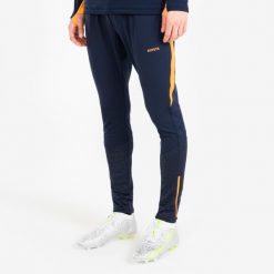 Spodnie piłkarskie Kipsta CLR. Brązowe spodnie materiałowe męskie KIPSTA, bez wzorów, z materiału, sportowe. Za 139.99 zł.
