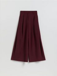 Spodnie z szerokimi nogawkami - bordowy. Czerwone spodnie materiałowe damskie Reserved, bez wzorów, z dzianiny. Za 179.99 zł.