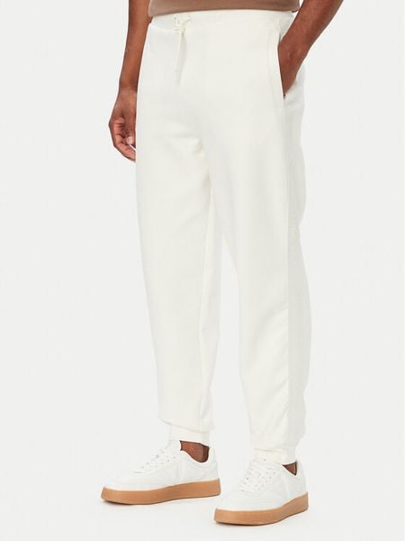 Guess Spodnie dresowe Z6YB13 K4965 Kremowy Regular Fit. Białe spodnie dresowe męskie Guess, z aplikacjami, z bawełny. Za 394.99 zł.