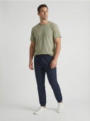 Bawełniane spodnie jogger - granatowy. Niebieskie spodnie materiałowe męskie Sinsay, bez wzorów, z bawełny. Za 49.99 zł.