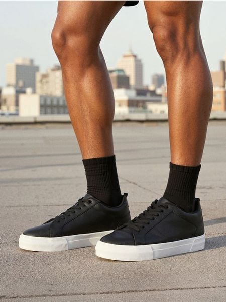 Sznurowane trampki z imitacji skóry - czarny. Czarne trampki i tenisówki męskie Sinsay, bez wzorów, ze skóry, bez zapięcia. W wyprzedaży za 39.99 zł.