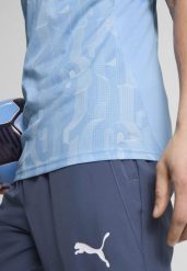 Męska koszulka przedmeczowa z krótkim rękawem Manchester City PUMA. Białe t-shirty sportowe męskie Puma, m, z dzianiny, bez ramiączek, do piłki nożnej. Za 239.89 zł.