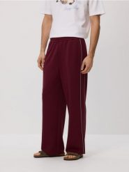 Spodnie loose fit - mahoniowy. Brązowe spodnie materiałowe męskie Reserved, bez wzorów, z dzianiny. W wyprzedaży za 55.99 zł.