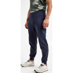 Spodnie dresowe ARMANI EXCHANGE. Spodnie dresowe męskie Armani Exchange, bez wzorów, z dresówki. W wyprzedaży za 312.17 zł.