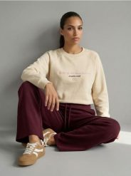 Bluza crewneck z haftowanym napisem NYC - kremowy. Białe bluzy bez kaptura damskie Sinsay, l. Za 39.99 zł.
