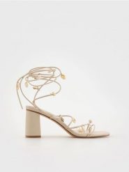 Sandały z ozdobnymi muszelkami - kremowy. Białe sandały damskie Reserved, bez wzorów, ze skóry, bez obcasa, na obcasie. W wyprzedaży za 79.99 zł.