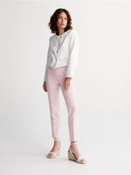 Spodnie z kantem - pastelowy róż. Czerwone spodnie materiałowe damskie Reserved, bez wzorów, z tkaniny. W wyprzedaży za 35.99 zł.