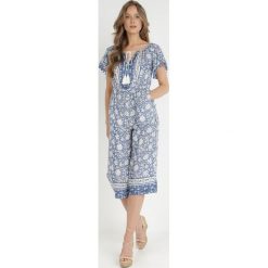 Niebieski Kombinezon Hesonia. Niebieskie kombinezony damskie Born2be, l, z aplikacjami, boho, bez kołnierzyka, bez ramiączek, krótkie. Za 44.99 zł.