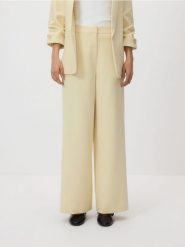 Spodnie z szerokimi nogawkami - jasnożółty. Żółte spodnie materiałowe damskie Reserved, bez wzorów, z tkaniny. Za 119.99 zł.