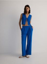 Gładkie spodnie - niebieski. Niebieskie spodnie materiałowe damskie Reserved, bez wzorów, z tkaniny. W wyprzedaży za 89.99 zł.