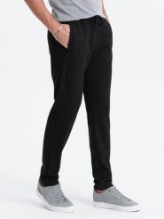 Męskie spodnie dresowe o marchewkowym kroju - czarne V1. Czarne spodnie dresowe męskie Ombre Clothing, bez wzorów, z dresówki. W wyprzedaży za 59.99 zł.