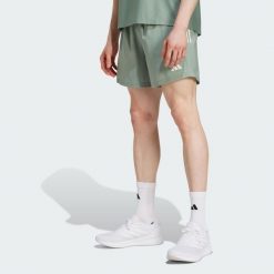 Szorty Own The Run. Zielone szorty męskie Adidas, z materiału, bez kołnierzyka. W wyprzedaży za 159.10 zł.
