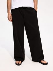Spodnie loose fit - czarny. Czarne spodnie materiałowe męskie Reserved, bez wzorów, z bawełny. Za 129.99 zł.