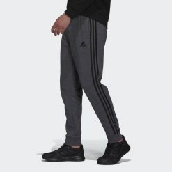 Spodnie męskie adidas Essentials French Terry Tapered Cuff 3-Stripes Pants. Czarne spodnie sportowe męskie Adidas. Za 182.00 zł.
