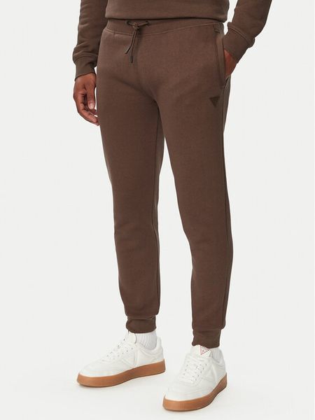 Guess Spodnie dresowe Z2YB22 K9V31 Brązowy Regular Fit. Brązowe spodnie dresowe męskie Guess, z aplikacjami, z bawełny. Za 294.99 zł.