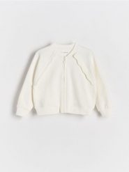 Rozpinana bluza z falbanką - złamana biel. Bluzy i bluzki niemowlęce Reserved, bez wzorów, z bawełny, bez ramiączek, bez kaptura. W wyprzedaży za 29.99 zł.