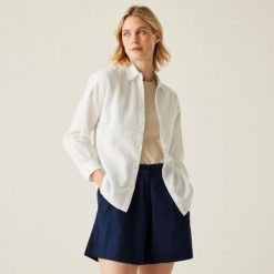 Koszula turystyczna damska Primevere. Białe koszule damskie Regatta, bez wzorów, z bawełny, bez kołnierzyka, bez ramiączek. W wyprzedaży za 190.50 zł.