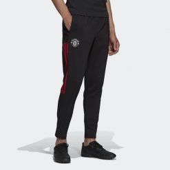 Spodnie joggingowe Manchester United Tiro. Czarne spodnie materiałowe męskie Adidas, bez wzorów, z materiału, klasyczne, z standardowym stanem. Za 212.80 zł.