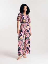 Kombinezon w kwiaty z wiskozy - granatowy. Niebieskie kombinezony damskie Reserved, l, bez wzorów, z wiskozy, bez kołnierzyka, bez ramiączek. W wyprzedaży za 69.99 zł.