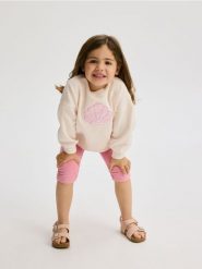 Bluza z aplikacją - kremowy. Białe bluzy i bluzki niemowlęce Reserved, z aplikacjami, z bawełny, bez ramiączek, bez kaptura. W wyprzedaży za 29.99 zł.