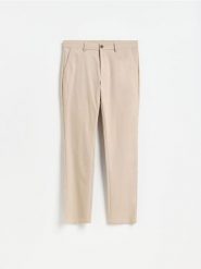 Gładkie spodnie chino slim - beżowy. Brązowe spodnie materiałowe męskie Reserved, bez wzorów, z bawełny. Za 159.99 zł.