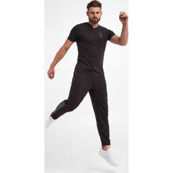 Spodnie dresowe ARMANI EXCHANGE. Spodnie dresowe męskie Armani Exchange, bez wzorów, z dresówki. W wyprzedaży za 415.17 zł.