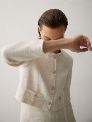 Krótki żakiet z tkaniny boucle - złamana biel. Marynarki i żakiety damskie Reserved, l, bez wzorów, z bawełny. W wyprzedaży za 119.99 zł.