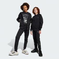 Spodnie Adidas Star Wars Mandalorian. Czarne spodnie dresowe damskie Adidas, bez wzorów, z materiału. W wyprzedaży za 149.40 zł.