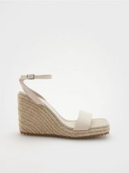 Sandały na koturnie - złamana biel. Sandały damskie Reserved, bez wzorów, ze skóry, bez obcasa, na koturnie. W wyprzedaży za 45.99 zł.