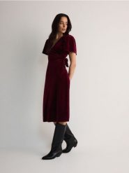 Aksamitna sukienka z wiązaniem - bordowy. Czerwone sukienki damskie Reserved, l, bez wzorów, z dzianiny, bez kołnierzyka, bez ramiączek, midi, rozkloszowane. W wyprzedaży za 109.99 zł.