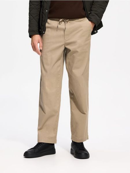 Spodnie wide leg - beżowy. Brązowe spodnie materiałowe męskie Reserved, bez wzorów, z dzianiny. Za 139.99 zł.