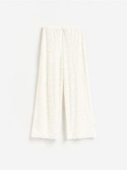 Żakardowe spodnie - złamana biel. Spodnie materiałowe damskie Reserved, bez wzorów, z dzianiny. Za 129.99 zł.