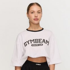 Koszulka damska fitness oversize biała Varsity. Białe topy sportowe damskie GYMBEAM, l, bez wzorów, z bawełny, bez ramiączek. Za 84.90 zł.