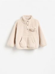 Bluza sherpa ze stójką - kremowy. Białe bluzy i bluzki niemowlęce Reserved, bez wzorów, z dzianiny, bez ramiączek, bez kaptura. Za 59.99 zł.