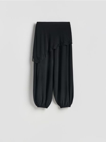 Spodnie balloon ze spódnicą - czarny. Czarne spodnie materiałowe damskie Reserved, bez wzorów, z dzianiny. Za 149.99 zł.