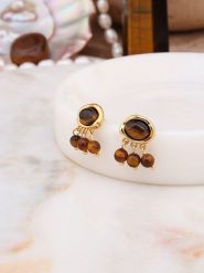 Pierres delicates Pozłacane kolczyki-wkrętki z tygrysim okiem rozmiar: onesize. Brązowe kolczyki damskie Pierres delicates, pozłacane. Za 43.99 zł.