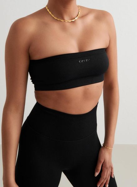 Damski biustonosz bandeau bez ramiączek, niskie wsparcie Shape Seamless czarny. Czarne biustonosze sportowe damskie Aim'n, bez wzorów, z dzianiny. Za 127.00 zł.