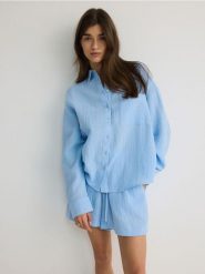 Szorty z bawełnianego muślinu - jasnoniebieski. Niebieskie szorty damskie Reserved, bez wzorów, z bawełny. W wyprzedaży za 59.99 zł.