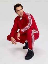 Sportowe spodnie z kontrastowymi lampasami - czerwony. Czerwone spodnie sportowe męskie Sinsay. Za 59.99 zł.