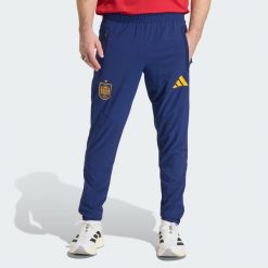 Spodnie Spain Tiro Travel. Niebieskie spodnie materiałowe męskie Adidas, bez wzorów, sportowe. Za 329.00 zł.