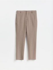 Gładkie spodnie chino slim - brązowy. Brązowe spodnie materiałowe męskie Reserved, bez wzorów, z tkaniny. Za 159.99 zł.