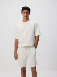Dresowe szorty regular fit - złamana biel. Szorty męskie Reserved, z bawełny, bez kołnierzyka. Za 79.99 zł.