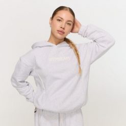 Bluza damska fitness z kapturem szara Varsity. Szare bluzy sportowe damskie GYMBEAM, l, z materiału. Za 139.90 zł.