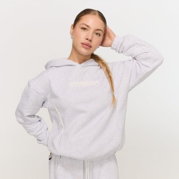 Bluza damska fitness z kapturem szara Varsity. Szare bluzy sportowe damskie GYMBEAM, l, z materiału. Za 139.90 zł.