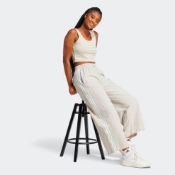 Spodnie damskie ADIDAS Essentials. Szare spodnie materiałowe damskie Adidas, bez wzorów, z materiału, eleganckie. Za 189.99 zł.