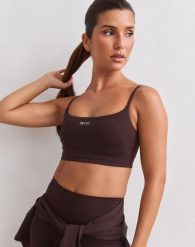 Damski biustonosz na ramiączkach z lekkim wsparciem Sculpting czekoladowy. Brązowe biustonosze sportowe damskie Aim'n, bez wzorów, z dzianiny. Za 217.00 zł.